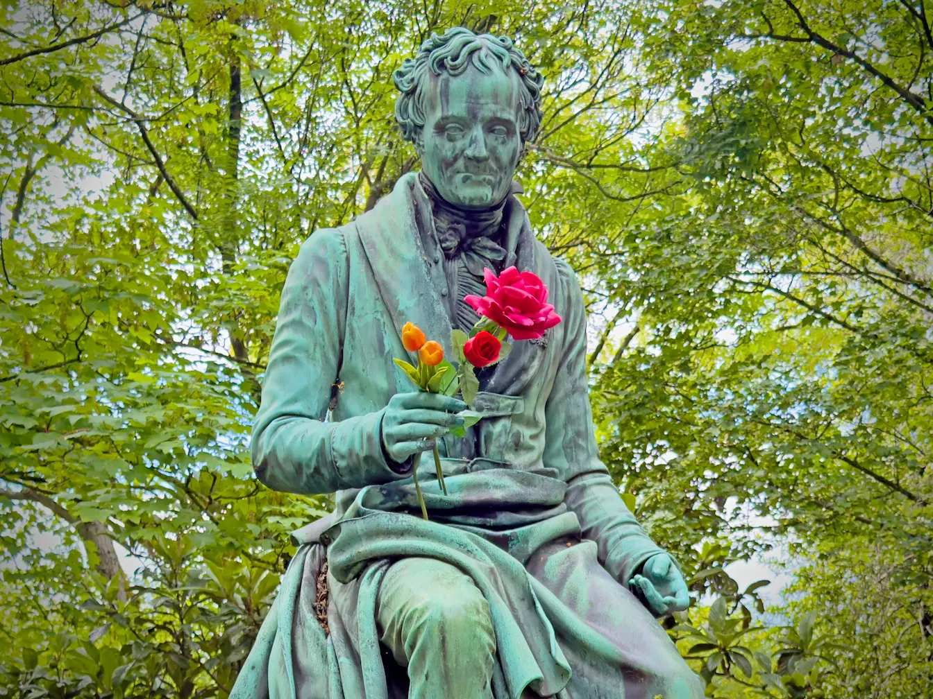 Statue en bronze patiné tenant des fleurs, art funéraire du Père-Lachaise